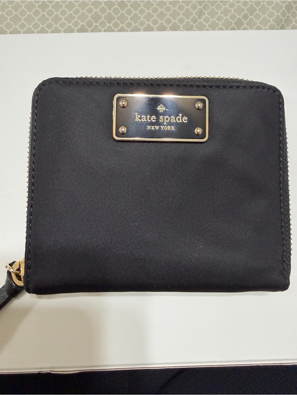 kate spade black nylon zip-around compact wallet with gold logo plaque